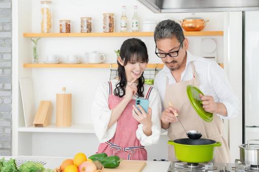 キッチンで料理を作るミドルの夫婦 キッチンで料理を作るミドルの夫婦 料理,夫婦,ミドルの写真素材