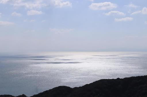 山の上から見た光る海 山の上から見た光る海の写真