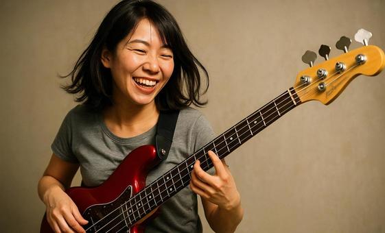 楽しそうにベースを弾く女性ミュージシャンの写真
