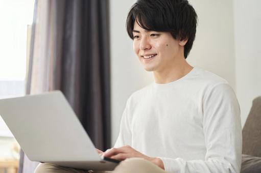 A man using a computer in his living room, máy tính xách tay pc, người, sống, JPG