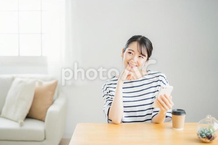 スマホを使う女性（笑顔） スマホ,女性,アプリの写真素材