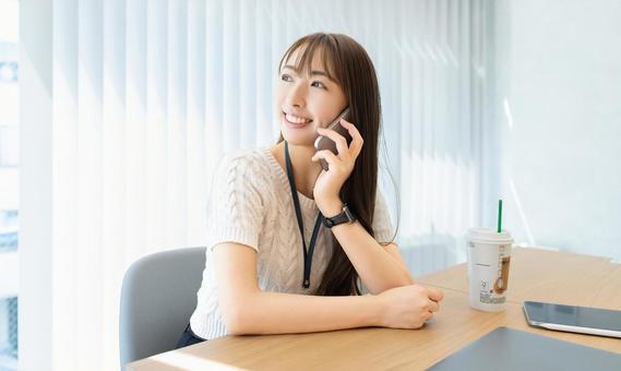 スマホで話す笑顔の女性・ビジネスウーマン 女性,スマホ,スマートフォンの写真素材
