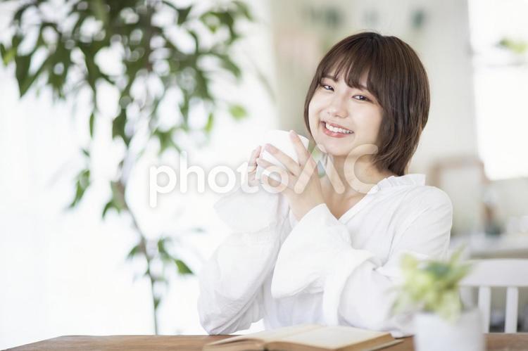 カップを持ち笑顔の女性 女性,日本人,読書の写真素材