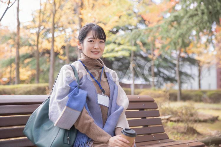 秋の公園でコーヒーを飲む会社員の女性（笑顔） 秋,女性,olの写真素材
