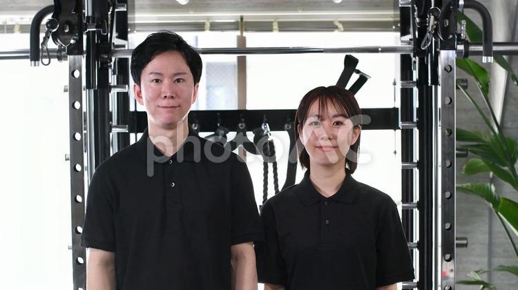 笑顔で並ぶジムのインストラクターの男女 ジム,スポーツジム,フィットネスの写真素材