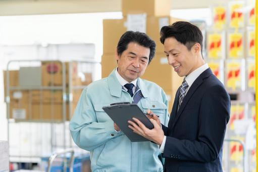 倉庫で商談をする経営者とビジネスマン 倉庫で商談をする経営者とビジネスマン 会議,倉庫,工場の写真素材