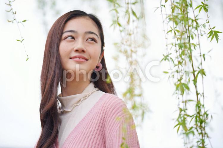 振り向いて遠くを見る女性 女性,大学生,春の写真素材