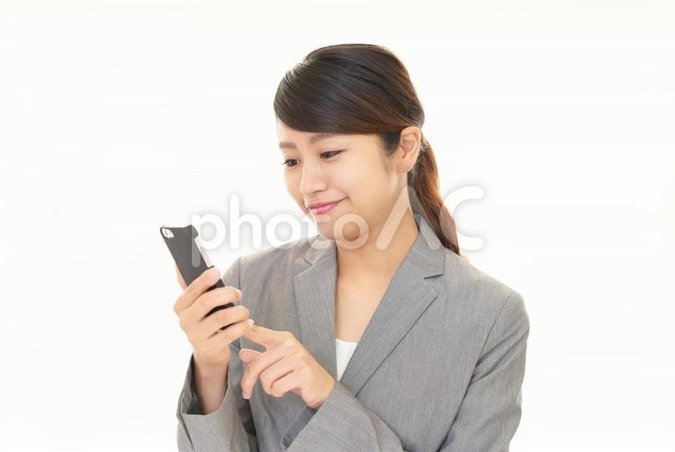 スマートフォンを持って操作する女性 女性,スマホ,スマートフォンの写真素材