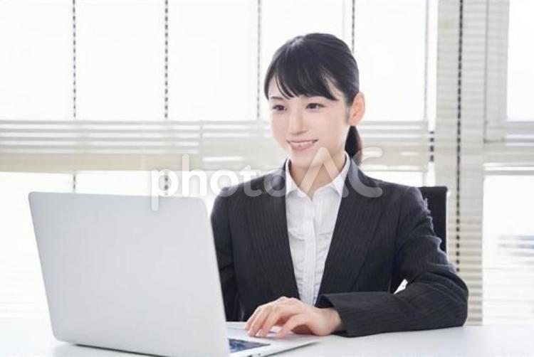 ノートパソコンを操作するビジネスウーマン 女性,笑顔,ビジネスウーマンの写真素材