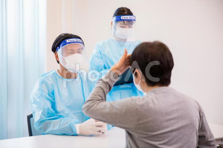 コロナ患者を担当する医師と熱のある患者 コロナ,コロナ禍,診察の写真素材
