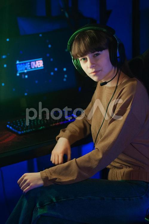 ゲームの前でカメラ目線で振り向く女性 ゲーム,ゲーマー,人物の写真素材