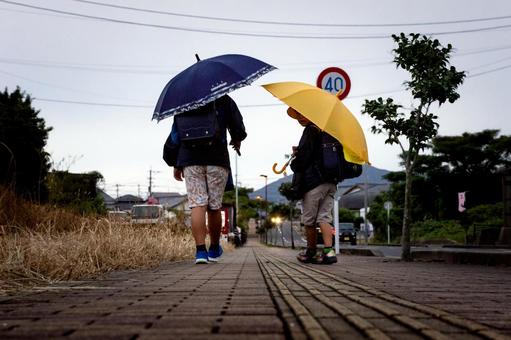 ＜素材＞雨の中で傘をさして登校する1年生 子供,兄弟,雨の写真素材