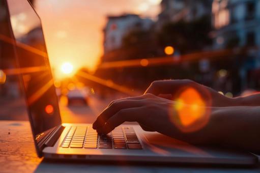 夕暮れにPCを閉じる働き方改革の象徴 夕暮れにPCを閉じる働き方改革の象徴の写真