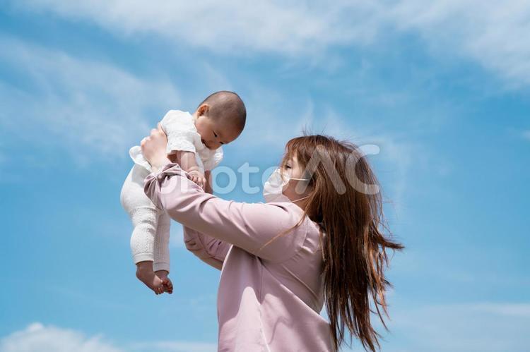 赤ちゃんを高い高いする女性（マスク） 赤ちゃん,ベビー,娘の写真素材