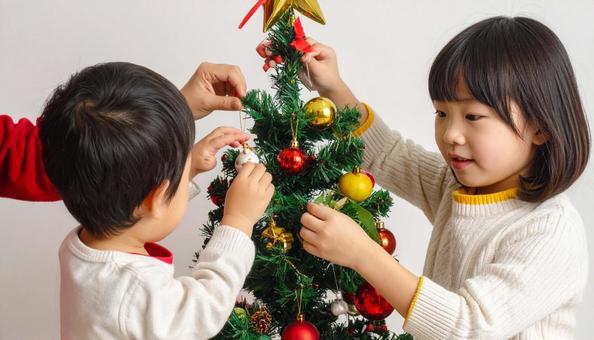 クリスマスツリーの飾りつけをする子ども クリスマスツリーの飾りつけをする子どもの写真