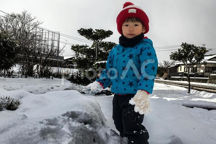 ＜素材＞雪の日に雪だるまを作る男の子 子供,雪遊び,雪の写真素材