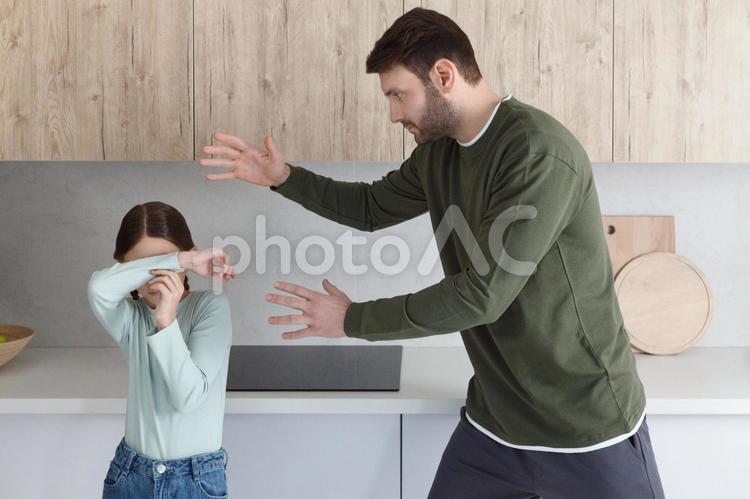 父親が起こっていておびえる娘 親子,女の子,男性の写真素材