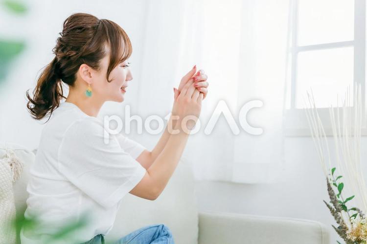 手の甲にハンドクリームを塗る日本人女性 ハンドクリーム,ハンドケア,あかぎれの写真素材