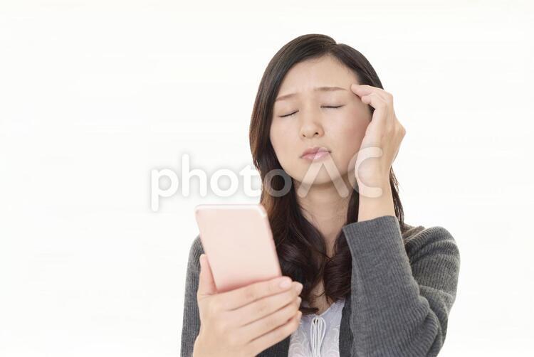 頭痛を訴える女性 女性,スマートフォン,携帯電話の写真素材