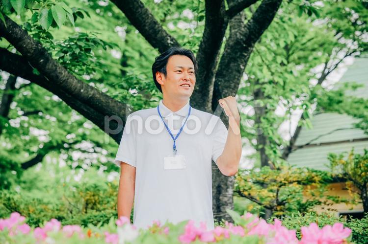 医療・介護・福祉系の男性スタッフ（ガッツポーズ） 介護士,ホームヘルパー,作業療法士の写真素材