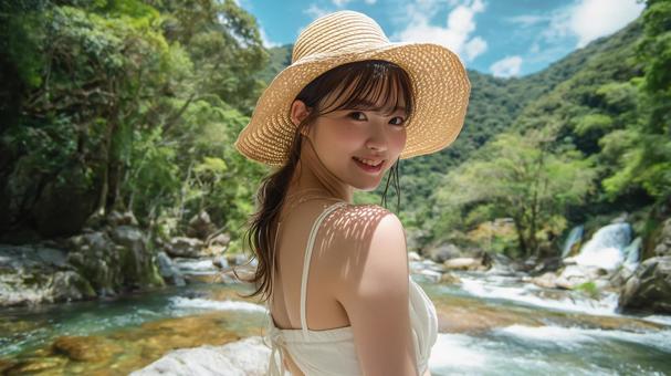 夏の渓流沿いの遊歩道に立つ若い日本人女性 夏の渓流沿いの遊歩道に立つ若い日本人女性の写真