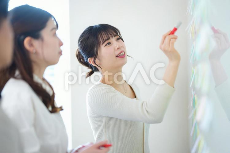付箋を見ながら話している女性たち 女性,見る,付箋の写真素材