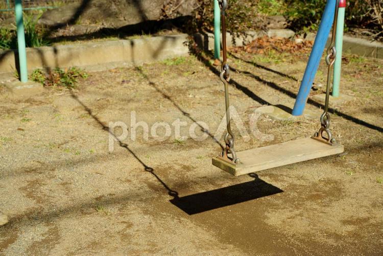 公園で、遊んでくれる人を待っているブランコの写真 遊具,ブランコ,公園の写真素材