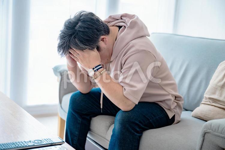 頭を抱える男性 男性,頭を抱える,悩むの写真素材
