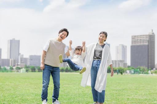 手を繋いで屋外を散歩する親子 手を繋いで屋外を散歩する親子 人物,家族,女性の写真素材
