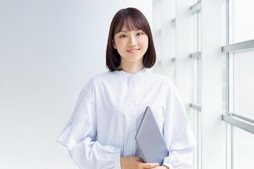パソコンを持つ女性・ビジネスウーマン パソコンを持つ女性・ビジネスウーマン 女性,パソコン,笑顔の写真素材