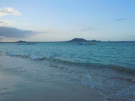 夕暮れの海でカヌーを漕ぐ人々(ハワイ) 夕暮れの海でカヌーを漕ぐ人々(ハワイ)の写真