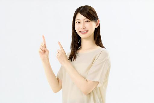 両手で指差しする若い女性 両手で指差しする若い女性 指差し,女性,笑顔の写真素材