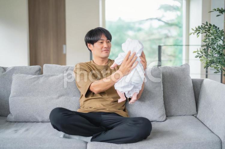 赤ちゃんの面倒を見る男性（笑顔） イクメン,赤ちゃん,育児の写真素材