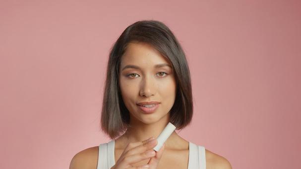 リップクリーム容器を見せる女性 リップクリーム容器を見せる女性 女性,外国人,アジア人の写真素材
