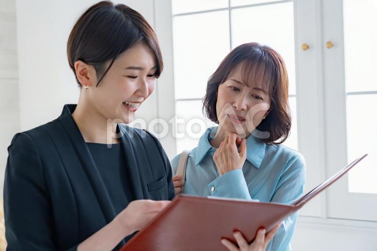 シニア女性とスーツを着た女性 レシェプション,受付,ビジネスウーマンの写真素材