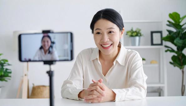 カメラ目線で会話する女性 カメラ目線で会話する女性の写真
