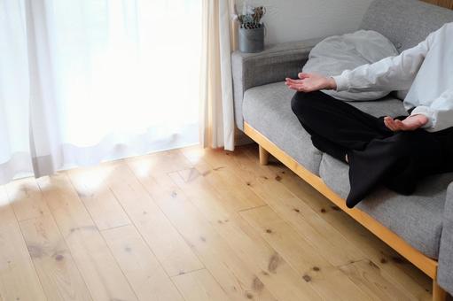 リビングのソファーであぐらをかく女性 マイホーム,リビング,女性の写真素材