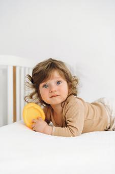 黄色い玩具を持ちカメラ目線の子供 黄色い玩具を持ちカメラ目線の子供 赤ちゃん,かわいい,育児の写真素材