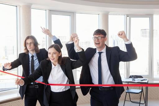 赤いテープの前に並びガッツポーズの3人 男女,外国人,ビジネスの写真素材