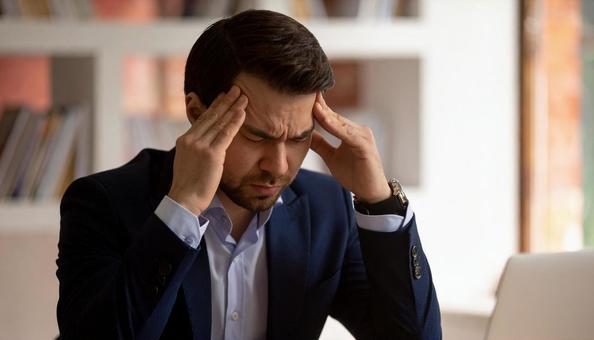 頭を押さえて悩む日本人男性ビジネスマン 頭を押さえて悩む日本人男性ビジネスマンの写真