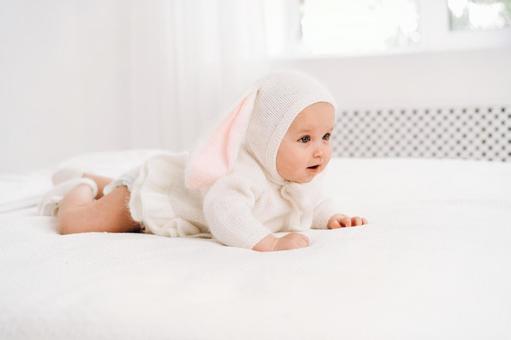 かわいいうさぎの服を着た横向きの赤ちゃん かわいいうさぎの服を着た横向きの赤ちゃん 赤ちゃん,かわいい,うさぎの写真素材