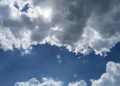 雨雲と入道雲に隠れる夏の太陽 雨雲と入道雲に隠れる夏の太陽の写真