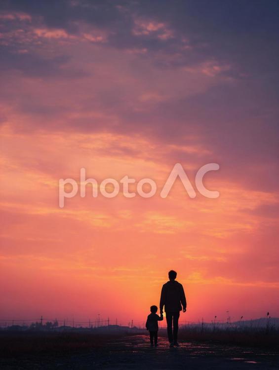夕焼けの空の下、手をつないで歩く父と子 父,親子,子供の写真素材