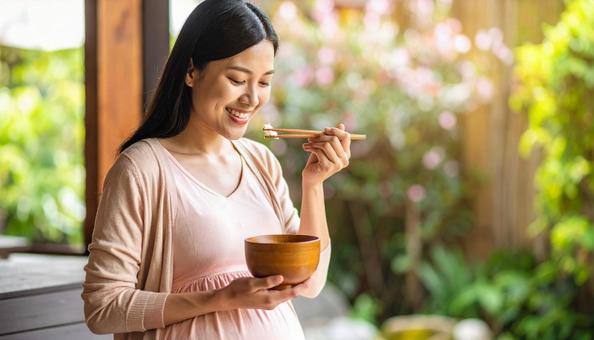 食事を美味しそうに食べる妊婦 食事を美味しそうに食べる妊婦の写真