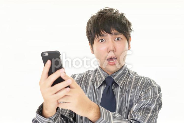 スマートフォンを持って驚く男性 男性,スマホ,ビジネスの写真素材