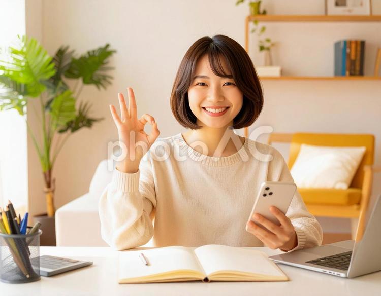 家計がうまくいきスマホ片手に微笑む女性 パソコン,家計簿,節約の写真素材