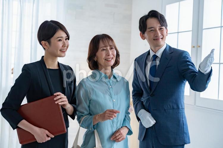 スーツの男女とシニアの女性 ショッピング,コンシェルジュ,ブランドの写真素材
