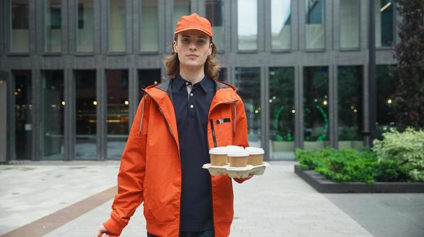 ドリンクを持って歩くフードデリバリーの男性 配達,デリバリー,配送の写真素材