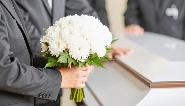 葬式でお棺に白い花束を捧げる人の手もと 葬式でお棺に白い花束を捧げる人の手もとの写真