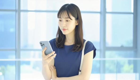 スマホを確認するビジネス女性 スマホを確認するビジネス女性の写真